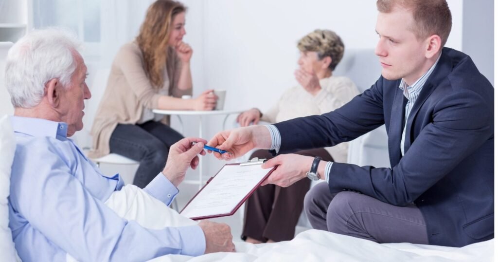Mobile notary bringing documents to an elderly man for signing at his bedside in a New Jersey care facility, family nearby